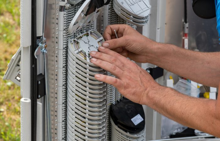 Engineer connecting fiber optic cable to the switch